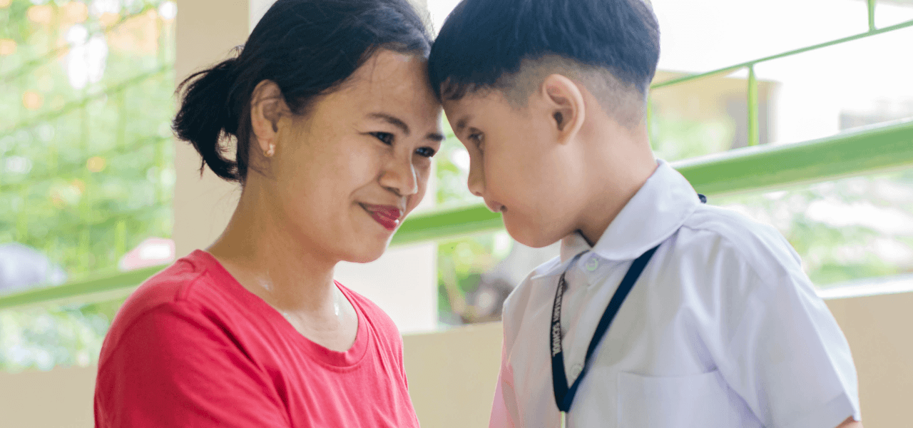 Photo: A woman and a child in uniform gaze at each other affectionately.